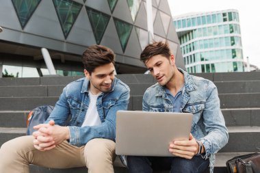 İki gülümseyen genç erkek arkadaşlar rahat giyinmiş