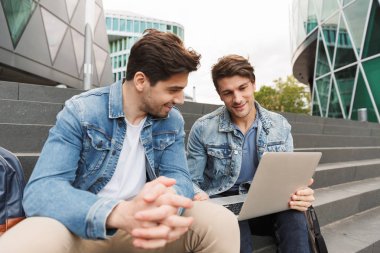 İki gülümseyen genç erkek arkadaşlar rahat giyinmiş