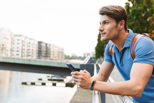 Guapo joven vestido casualmente pasar tiempo al aire libre — Foto de Stock