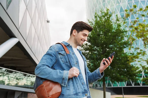 Guapo joven vestido casualmente pasar tiempo al aire libre — Foto de Stock