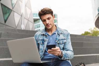 Yakışıklı genç adam rahat açık havada vakit geçirmek giymiş