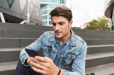 Yakışıklı genç adam rahat açık havada vakit geçirmek giymiş