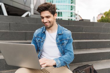 Yakışıklı genç adam rahat açık havada vakit geçirmek giymiş