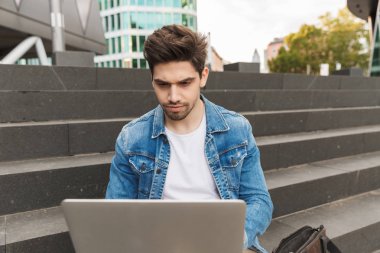 Yakışıklı genç adam rahat açık havada vakit geçirmek giymiş