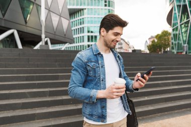 Yakışıklı genç adam rahat açık havada vakit geçirmek giymiş