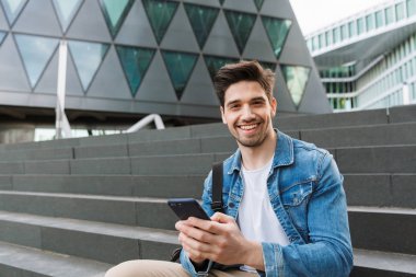 Yakışıklı genç adam rahat açık havada vakit geçirmek giymiş