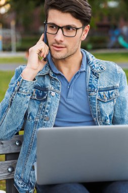 Yakışıklı genç adam rahat açık havada vakit geçirmek giymiş