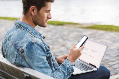 Yakışıklı genç adam rahat açık havada vakit geçirmek giymiş