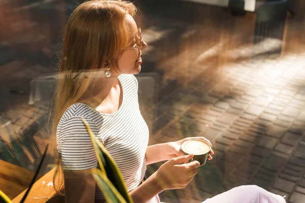 Sokak kafeaçık otururken gülümseyen ve kahve fincanı tutan muhteşem genç kadın Görüntü