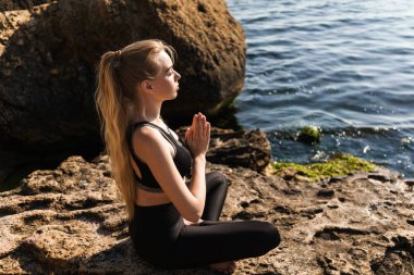 Plajda otururken meditasyon güzel sakin genç kız