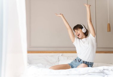 Neşeli genç güzel kadın evde evde evde oturan kulaklık ile müzik dinleme.