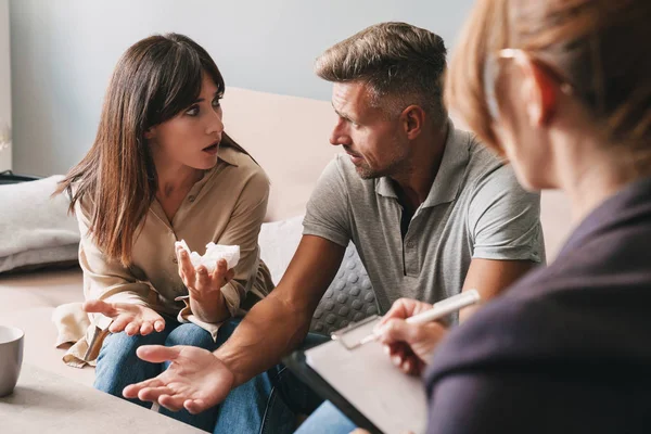 Foto van geïrriteerd ongelukkig paar met een gesprek met psycholoog op therapiesessie in de kamer — Stockfoto