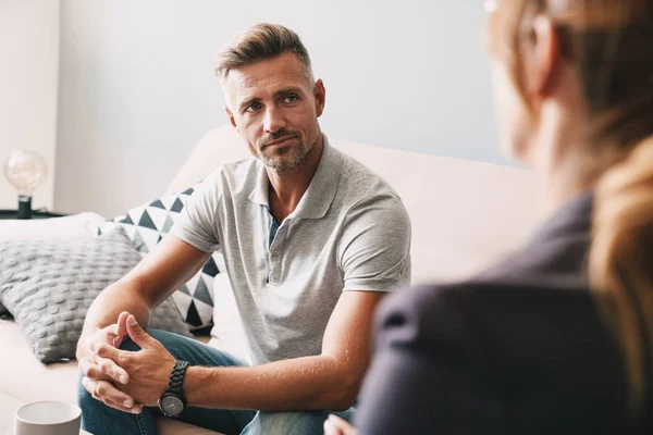 Foto de homem focado confiante conversando com psicólogo no quarto — Fotografia de Stock