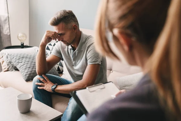 Foto de homem frustrado chateado ter conversa com psicólogo no quarto — Fotografia de Stock