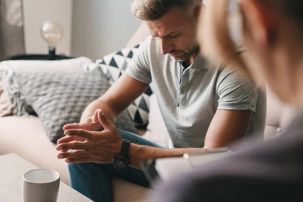 Foto de homem concentrado pensativo conversando com psicólogo no quarto — Fotografia de Stock