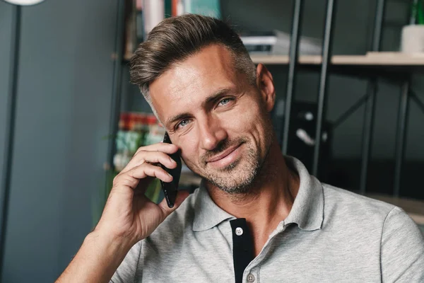 Photo closeup of beautiful caucasian man talking on smartphone while resting at home — Stock Photo, Image