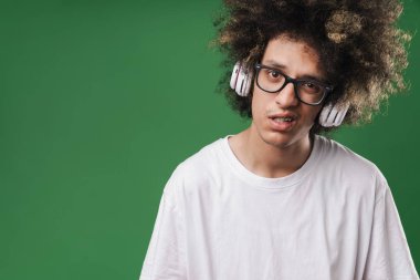 Kulaklık kullanırken kamera bakarak afro saç modeli ile hoşnutsuz adam Fotoğraf closeup