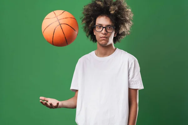Portret van jonge serieuze man met Afro kapsel spelen met bal en kijken naar camera — Stockfoto