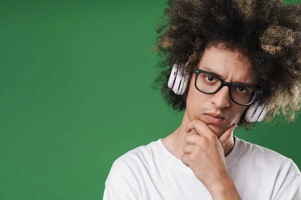 Fotografie pochmurného mladého muže se stylem účesu, který mu prodlužuje hlavu a používá sluchátka — Stock fotografie