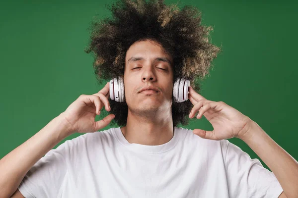 Fotografie relaxace mladého muže s očima zavřených naslouchající hudby se sluchátky — Stock fotografie