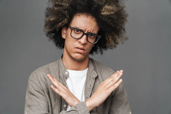 Sad displeased teenage guy posing isolated over grey wall background showing stop gesture. — Stock Photo, Image