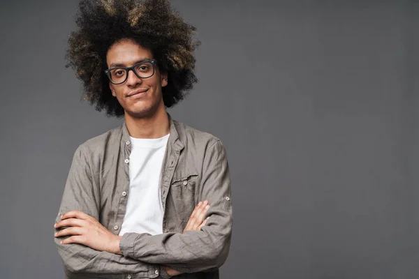 Foto de jovem satisfeito com penteado afro batendo com os braços cruzados e sorrindo — Fotografia de Stock