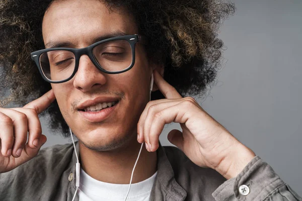 Foto närbild av unga avslappnad man med slutna ögon leende och lyssna musik med hörlurar — Stockfoto