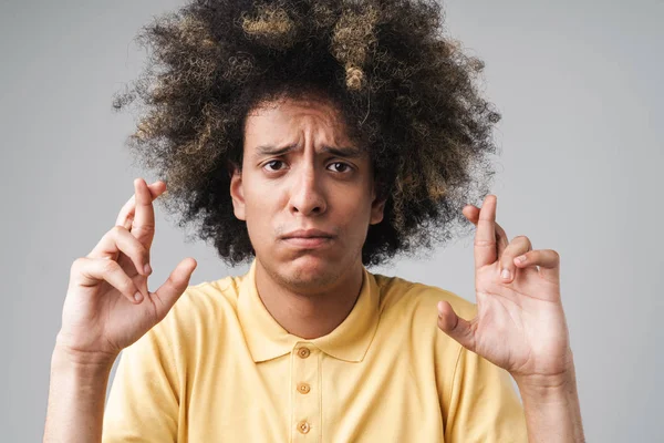 Foto de un hombre caucásico perplejo con un peinado afro frunciendo el ceño —  Fotos de Stock