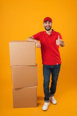 Başparmak u gösteren kırmızı üniformalı yakışıklı teslimat adam Portresi