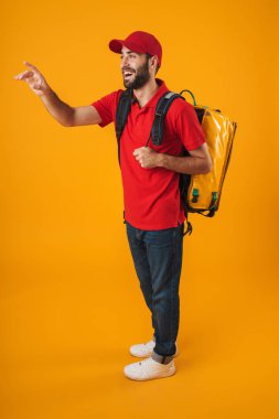 Sırt çantası taşıyan kırmızı üniformalı neşeli teslimatçı nın görüntüsü 