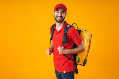 Sırt çantası w taşıyan kırmızı üniformalı gülümseyen teslimat adam fotoğrafı
