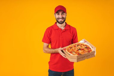 Kırmızı üniformalı mutlu teslimatçı adamın fotoğrafı gülümseyerek ve p tutarak