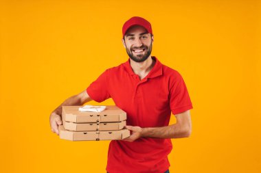 Kırmızı üniformalı mutlu teslimatçı nın portresi gülümseyerek ve holdin