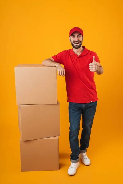 Retrato de homem de entrega bonito em uniforme vermelho mostrando polegar u — Fotografia de Stock