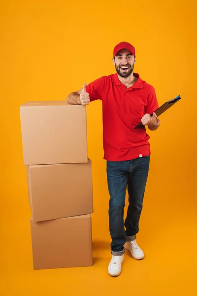 Retrato de homem de entrega caucasiano em vermelho uniforme segurando clipbo — Fotografia de Stock