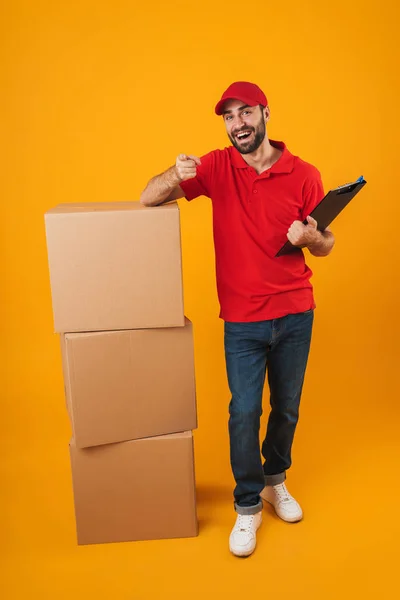 Retrato de jovem entregador em vermelho uniforme segurando prancheta — Fotografia de Stock