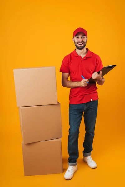 Retrato de homem de entrega otimista em vermelho uniforme segurando clipb — Fotografia de Stock