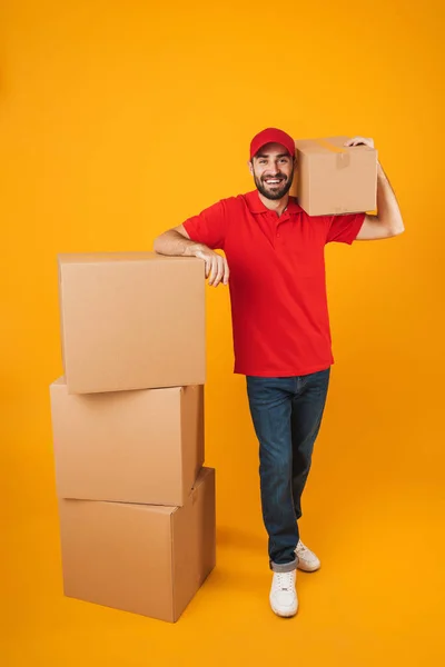 Imagem de comprimento total do homem de entrega alegre no sorriso uniforme vermelho — Fotografia de Stock