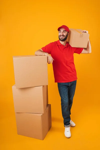 Imagem de comprimento total do homem de entrega feliz em vermelho uniforme sorrindo w — Fotografia de Stock