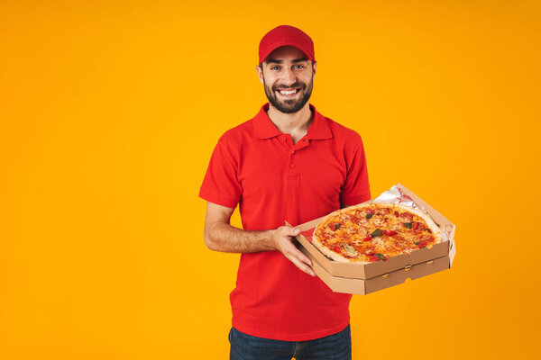 Photo of happy delivery man in red uniform smiling and holding p