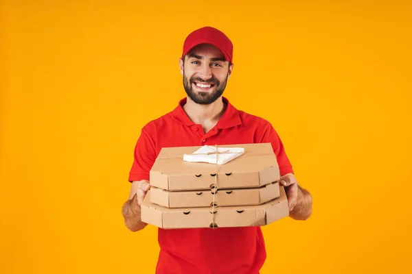 Porträt eines kaukasischen Lieferanten in roter Uniform, der lächelt und — Stockfoto