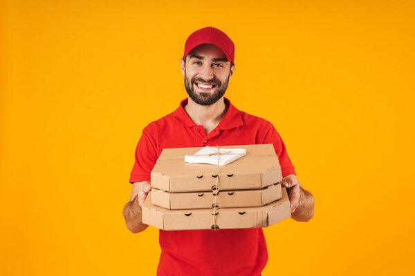 Portrait of caucasian delivery man in red uniform smiling and ho
