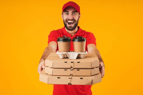 Porträt eines unrasierten Zustellers in roter Uniform, der eine Pizza hält — Stockfoto
