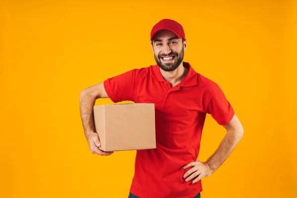 Retrato de homem de entrega alegre em vermelho uniforme sorrindo e hol — Fotografia de Stock