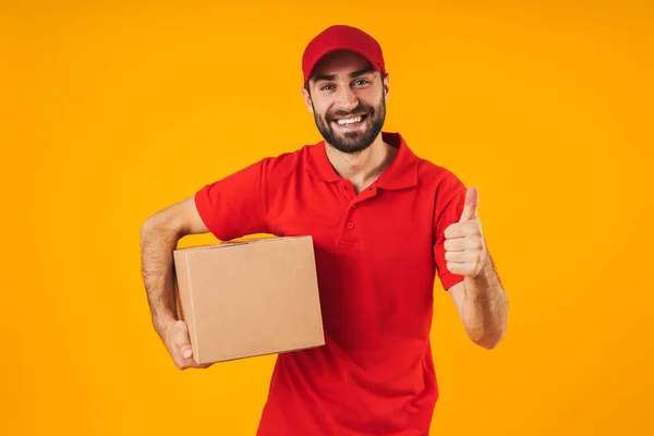 Retrato de homem de entrega atraente em uniforme vermelho mostrando polegar — Fotografia de Stock