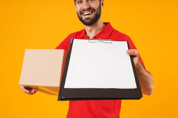 Image of handsome delivery man in red uniform holding clipboard — Stock Photo, Image