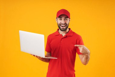 Kırmızı t-shirt ve kap gülümseyerek ve gümüş dizüstü bilgisayar tutan traşsız teslimat adam Portresi