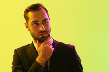 Düşünceli genç işadamının çenesine dokunan resmi takım elbiseli görüntüsü