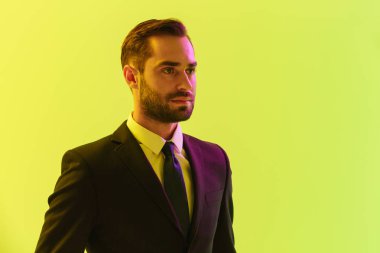 Resmi takım elbiseli başarılı yakışıklı işadamının görüntüsü kenara bakıyor