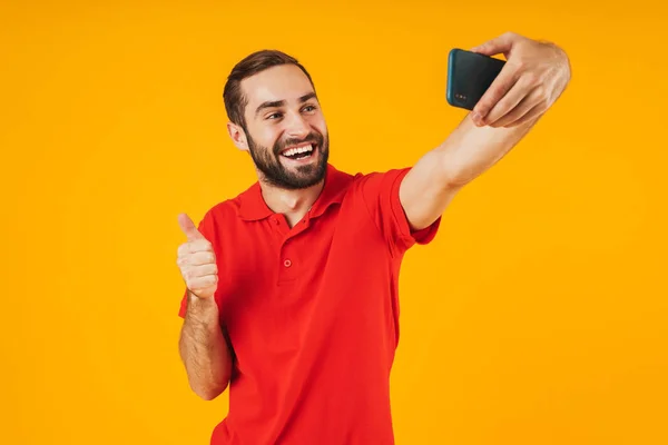 Retrato de hombre atractivo en camiseta roja riendo y mostrando t — Foto de Stock